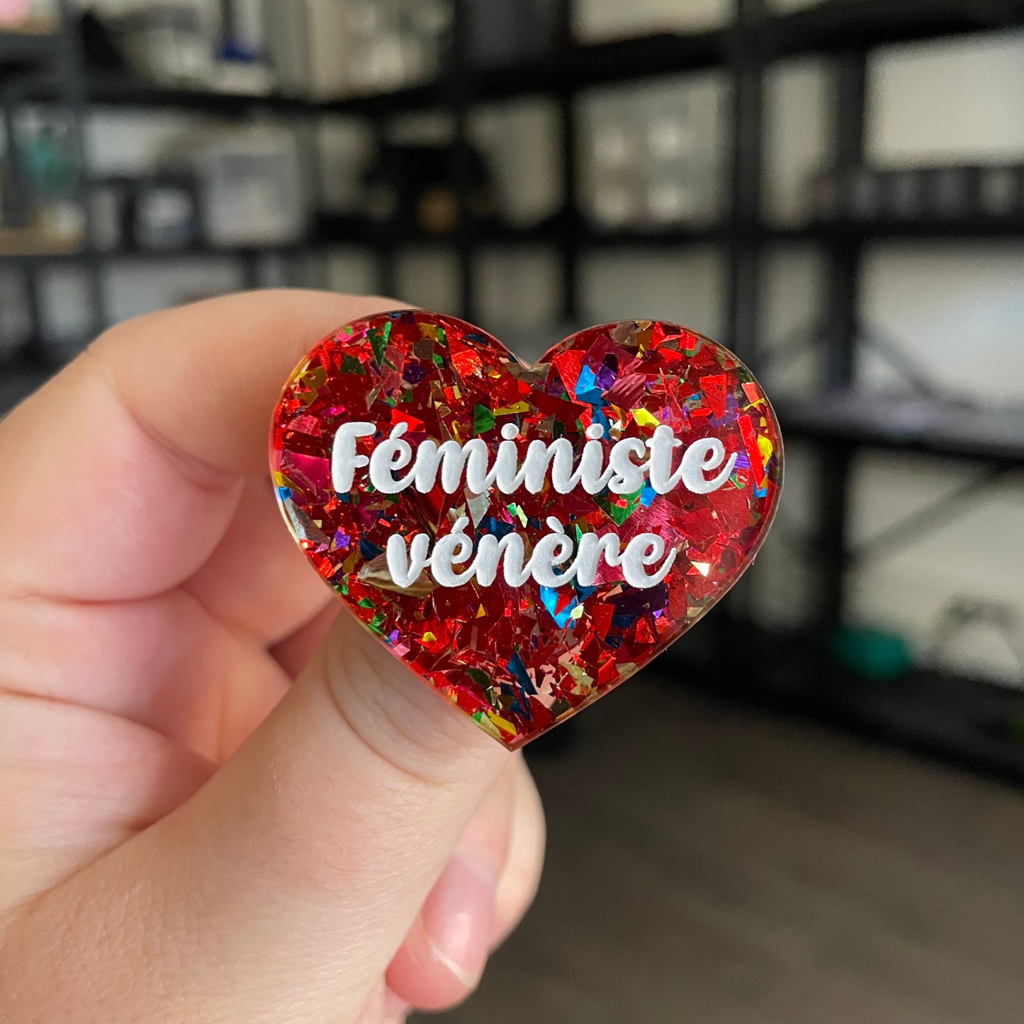 Broche "Féministe vénère" en acrylique transparente avec des éclats de confettis rouges et multicolores