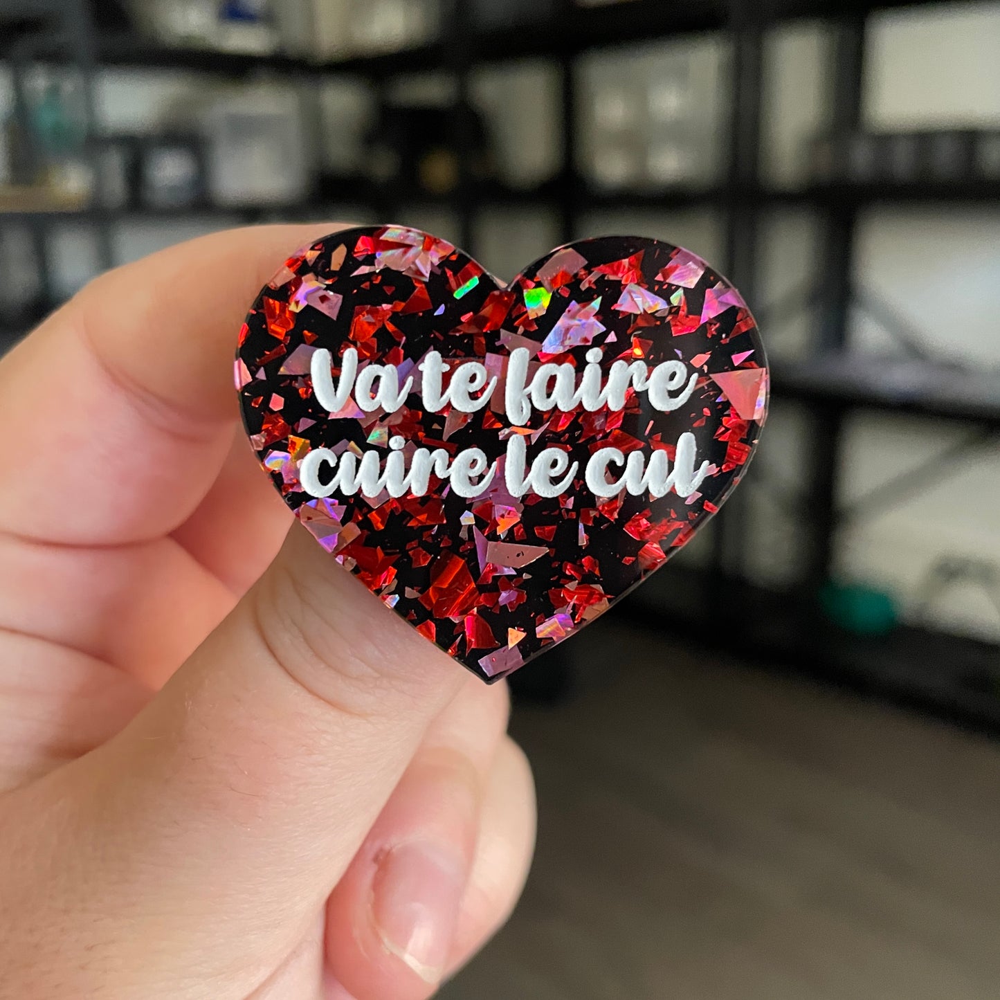 Broche "Va te faire cuire le cul" en acrylique noire avec des éclats de confettis rouges et roses