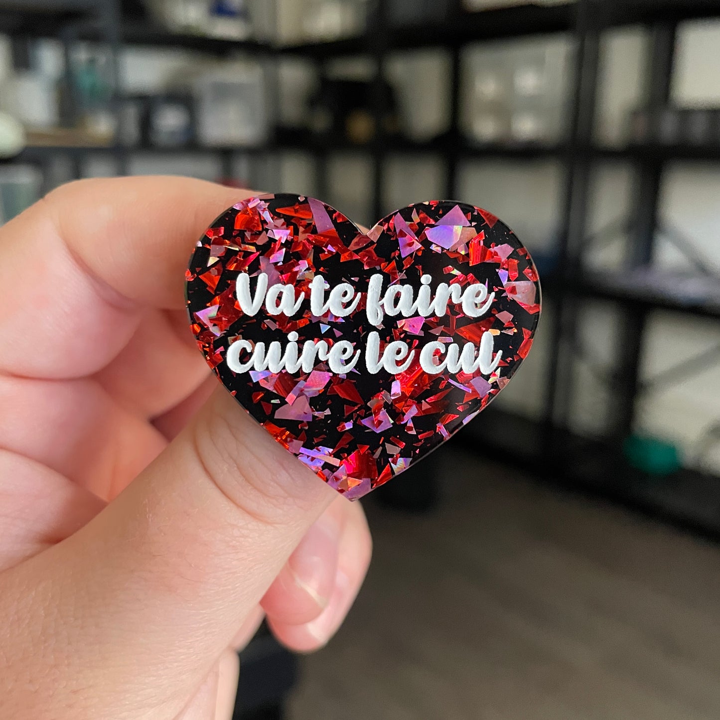 Broche "Va te faire cuire le cul" en acrylique noire avec des éclats de confettis rouges et roses