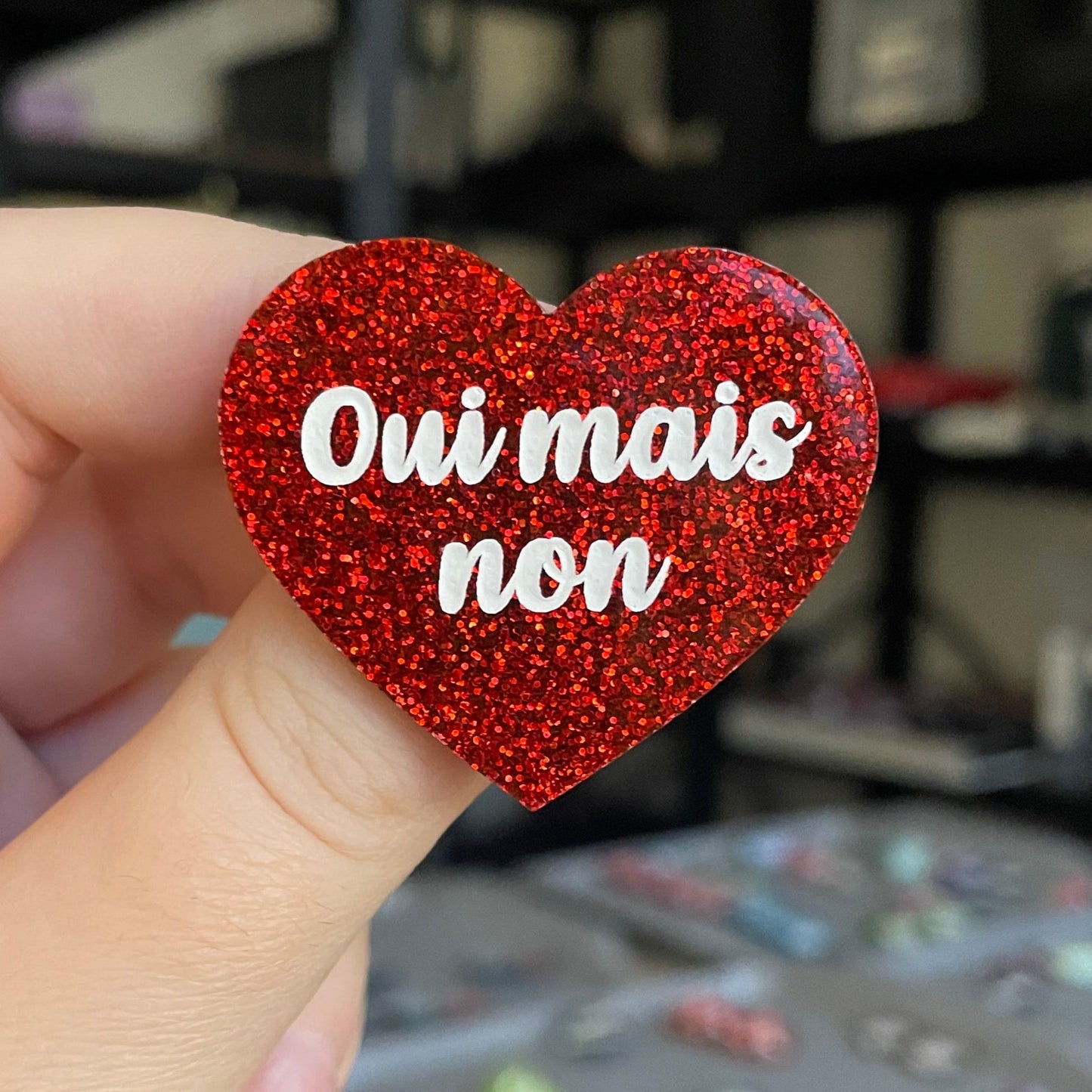 Broche "Oui mais non" en acrylique à paillettes rouges