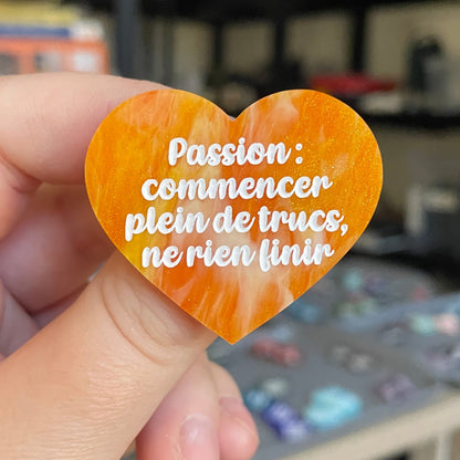 Broche "Passion : commencer plein de trucs, ne rien finir" en acrylique marbrée orange et dorée à paillettes