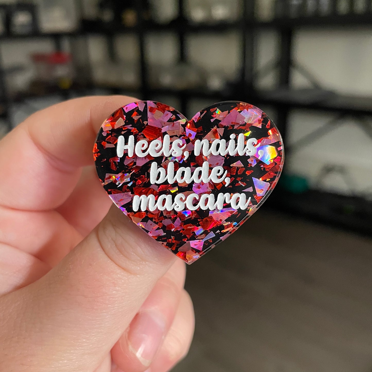 [CONTRÔLE TECHNIQUE] Broche "Heels, nails, blade, mascara" en acrylique noire avec des éclats de confettis rouges et roses