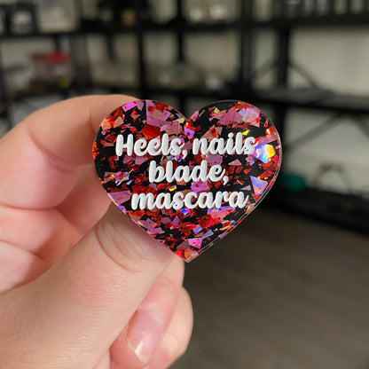 [CONTRÔLE TECHNIQUE] Broche "Heels, nails, blade, mascara" en acrylique noire avec des éclats de confettis rouges et roses