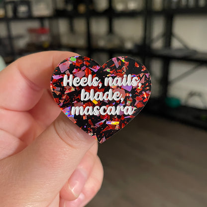 [CONTRÔLE TECHNIQUE] Broche "Heels, nails, blade, mascara" en acrylique noire avec des éclats de confettis rouges et roses