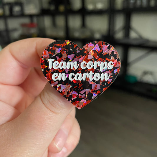 [CONTRÔLE TECHNIQUE] Broche "Team corps en carton" en acrylique noire avec des éclats de confettis rouges et roses