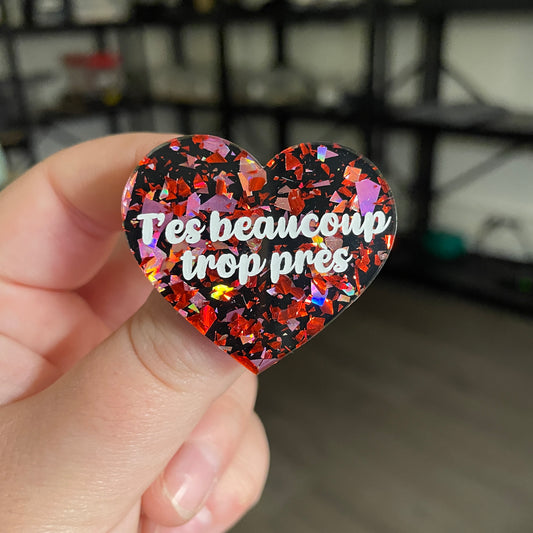 [CONTRÔLE TECHNIQUE] Broche "T'es beaucoup trop près" en acrylique noire avec des éclats de confettis rouges et roses
