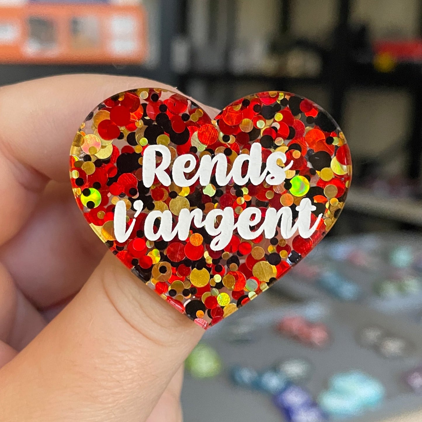 Broche "Rends l'argent" en acrylique semi-transparente à pois rouges, dorés et noirs