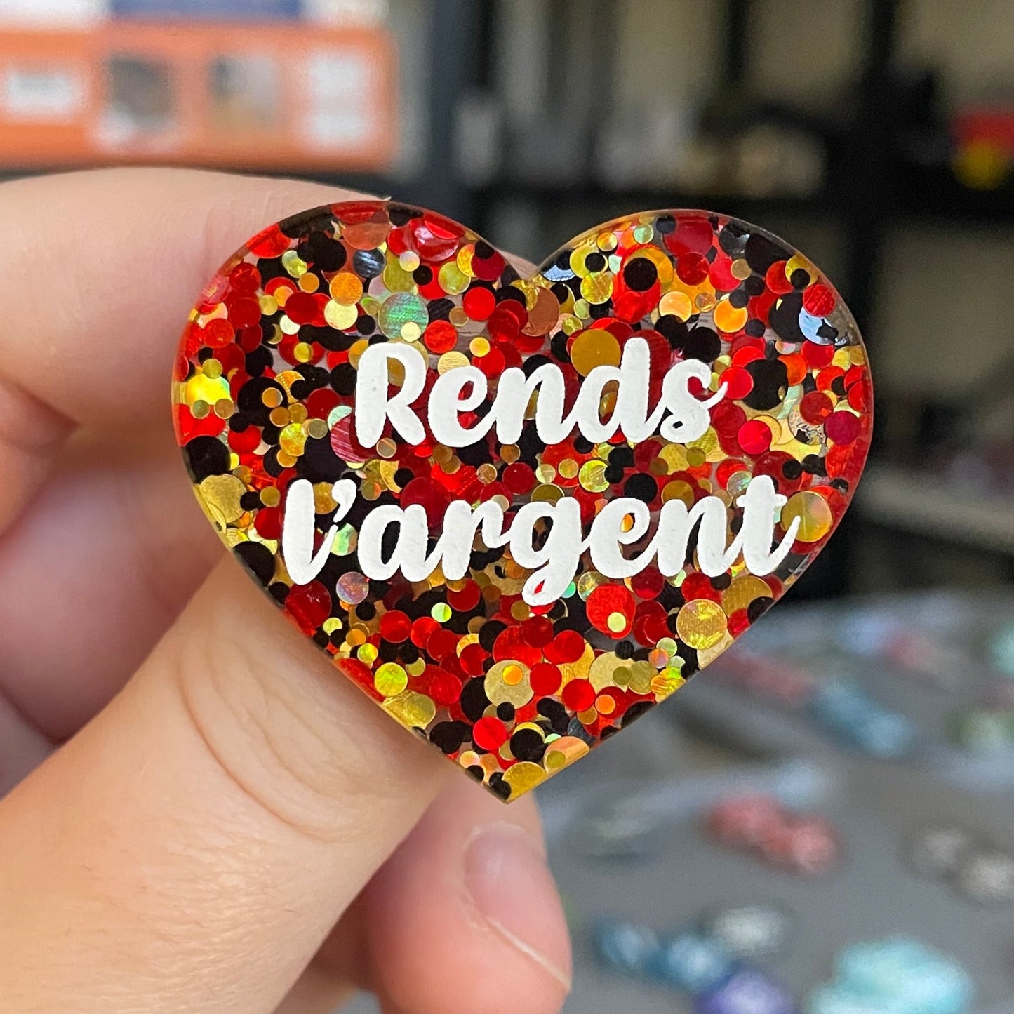 Broche "Rends l'argent" en acrylique semi-transparente à pois rouges, dorés et noirs