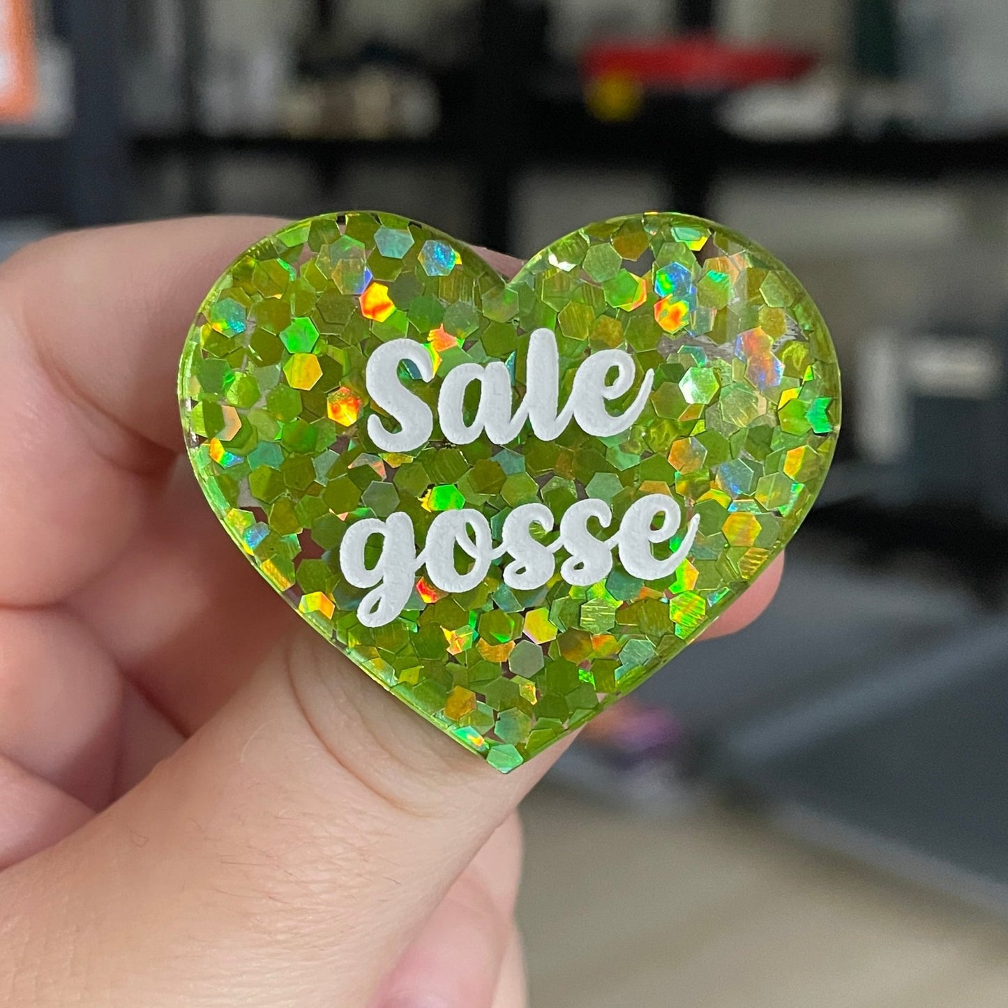 Broche "Sale gosse" en acrylique semi-transparente avec des confettis verts