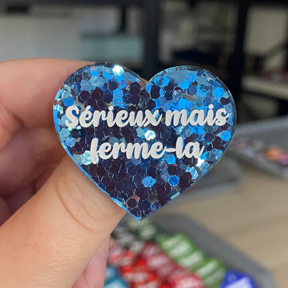 Broche "Sérieux mais ferme-la" en acrylique semi-transparente avec des confettis bleus