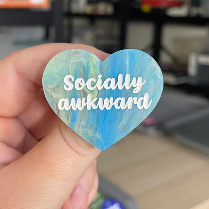 Broche "Socially awkward" en acrylique marbrée semi-transparente bleue, turquoise, blanche et jaune à paillettes
