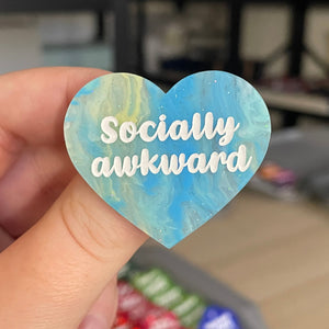 Broche "Socially awkward" en acrylique marbrée semi-transparente bleue, turquoise, blanche et jaune à paillettes