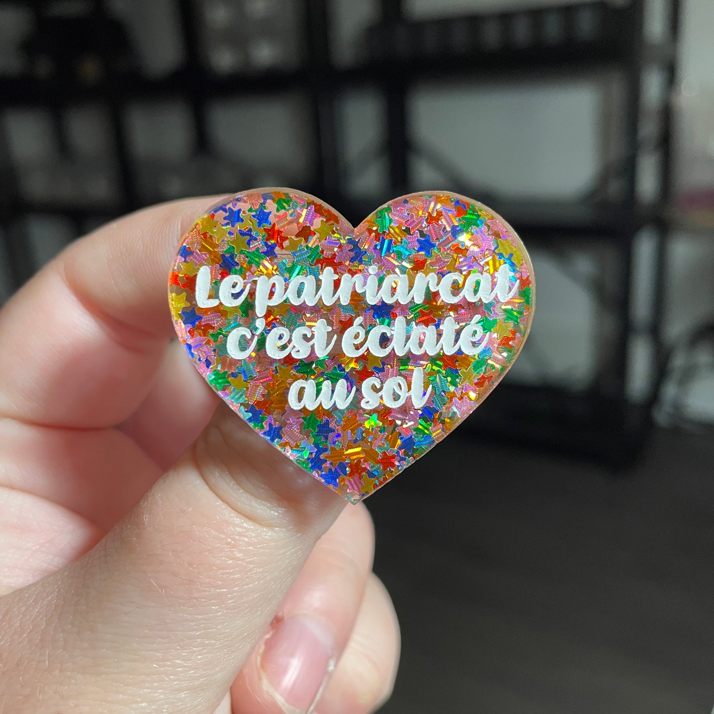 [CONTRÔLE TECHNIQUE] Broche "Le patriarcat c'est éclaté au sol" en acrylique semi transparente avec des confettis étoiles multicolores