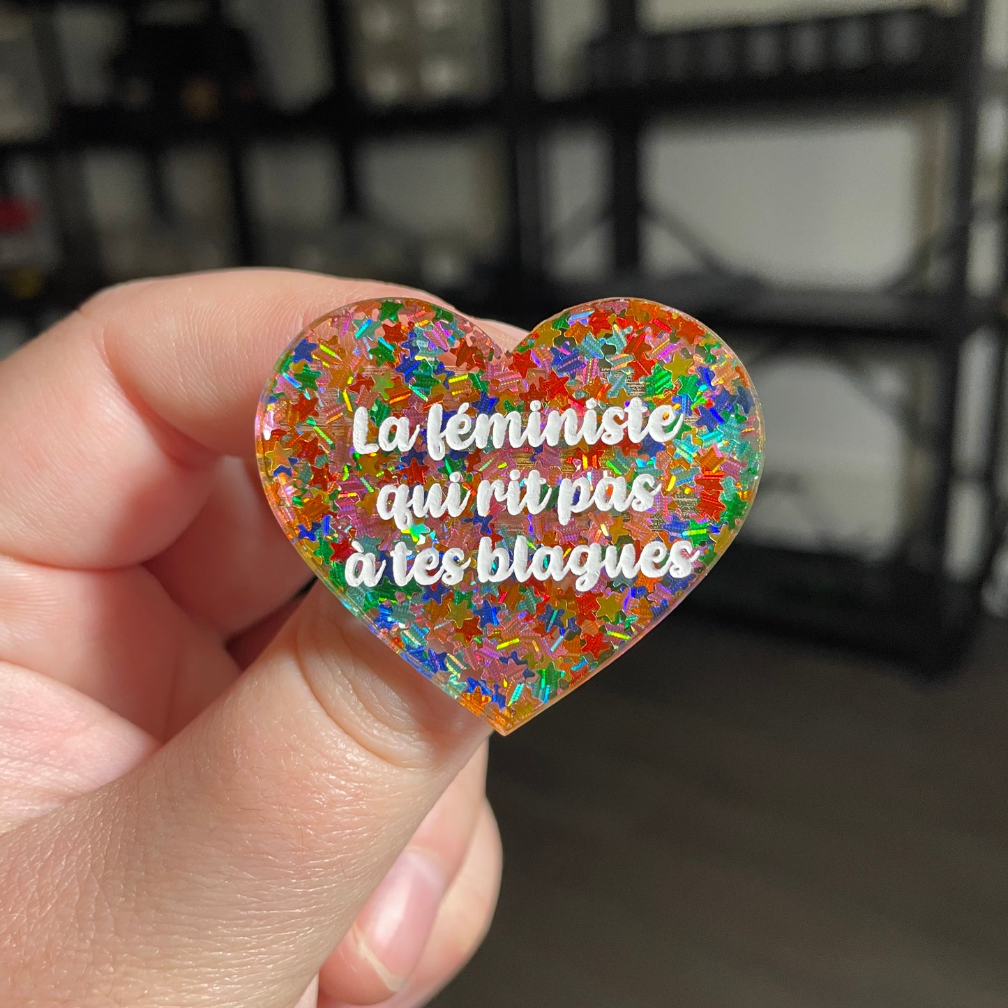 [CONTRÔLE TECHNIQUE] Broche "La féministe qui rit pas à tes blagues" en acrylique semi transparente avec des confettis étoiles multicolores