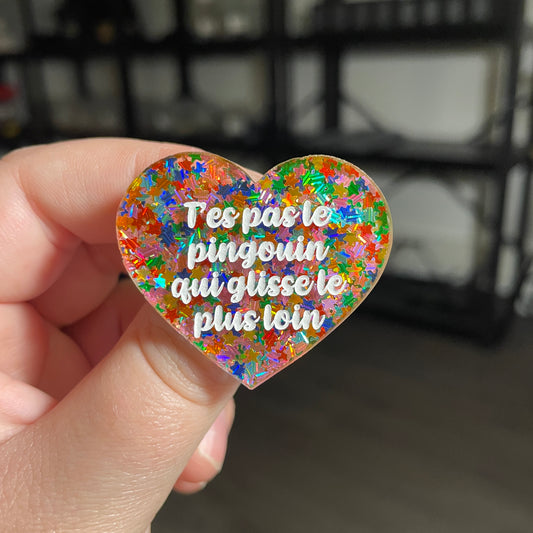 [CONTRÔLE TECHNIQUE] Broche "T'es pas le pingouin qui glisse le plus loin" en acrylique semi transparente avec des confettis étoiles multicolores