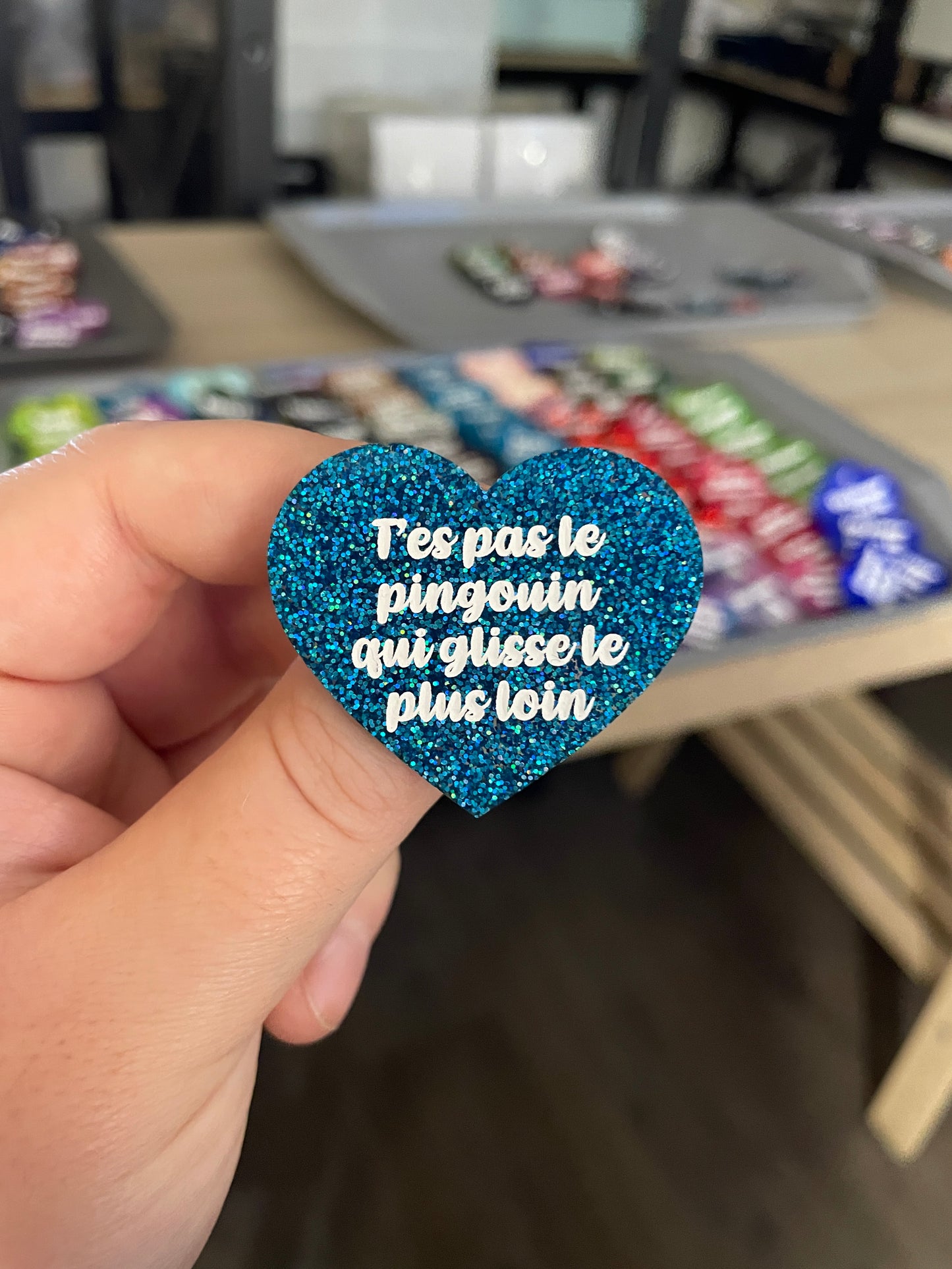 Broche "T'es pas le pingouin qui glisse le plus loin" en acrylique à paillettes bleues
