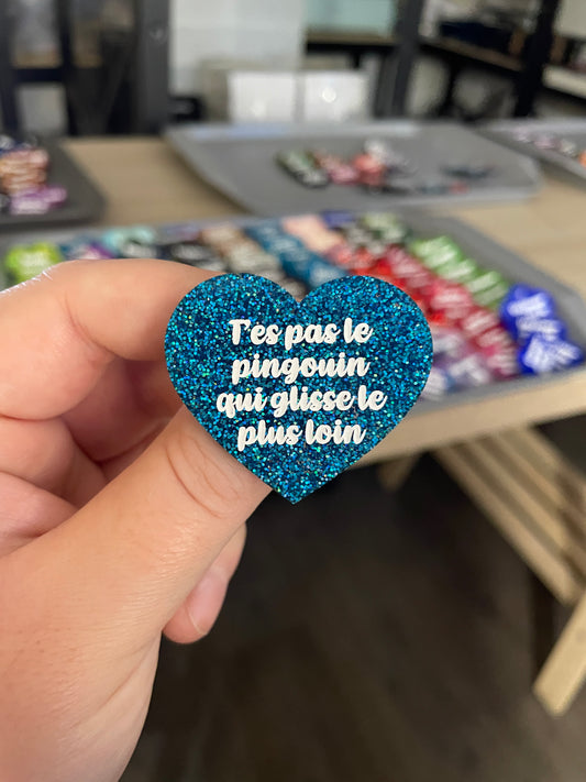 Broche "T'es pas le pingouin qui glisse le plus loin" en acrylique à paillettes bleues