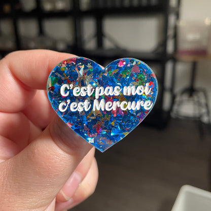 [CONTRÔLE TECHNIQUE] Broche "C'est pas moi c'est Mercure" en acrylique transparente avec des confettis bleus et multicolores