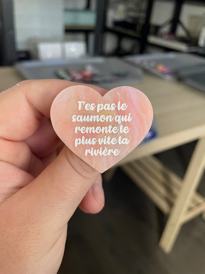 Broche "T'es pas le saumon qui remonte le plus vite la rivière" en acrylique marbrée semi-transparente orange, corail, blanche et jaune à paillettes