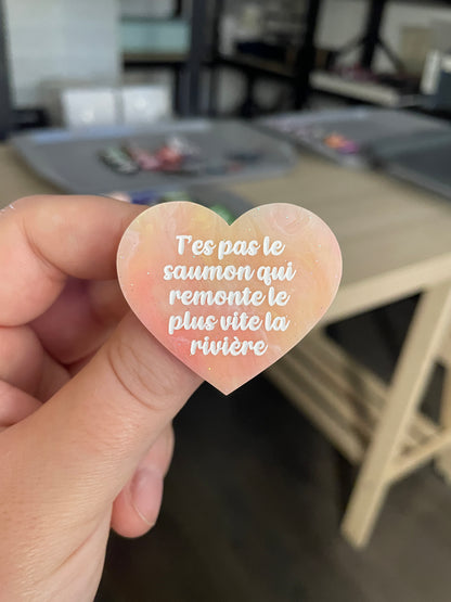 Broche "T'es pas le saumon qui remonte le plus vite la rivière" en acrylique marbrée semi-transparente orange, corail, blanche et jaune à paillettes