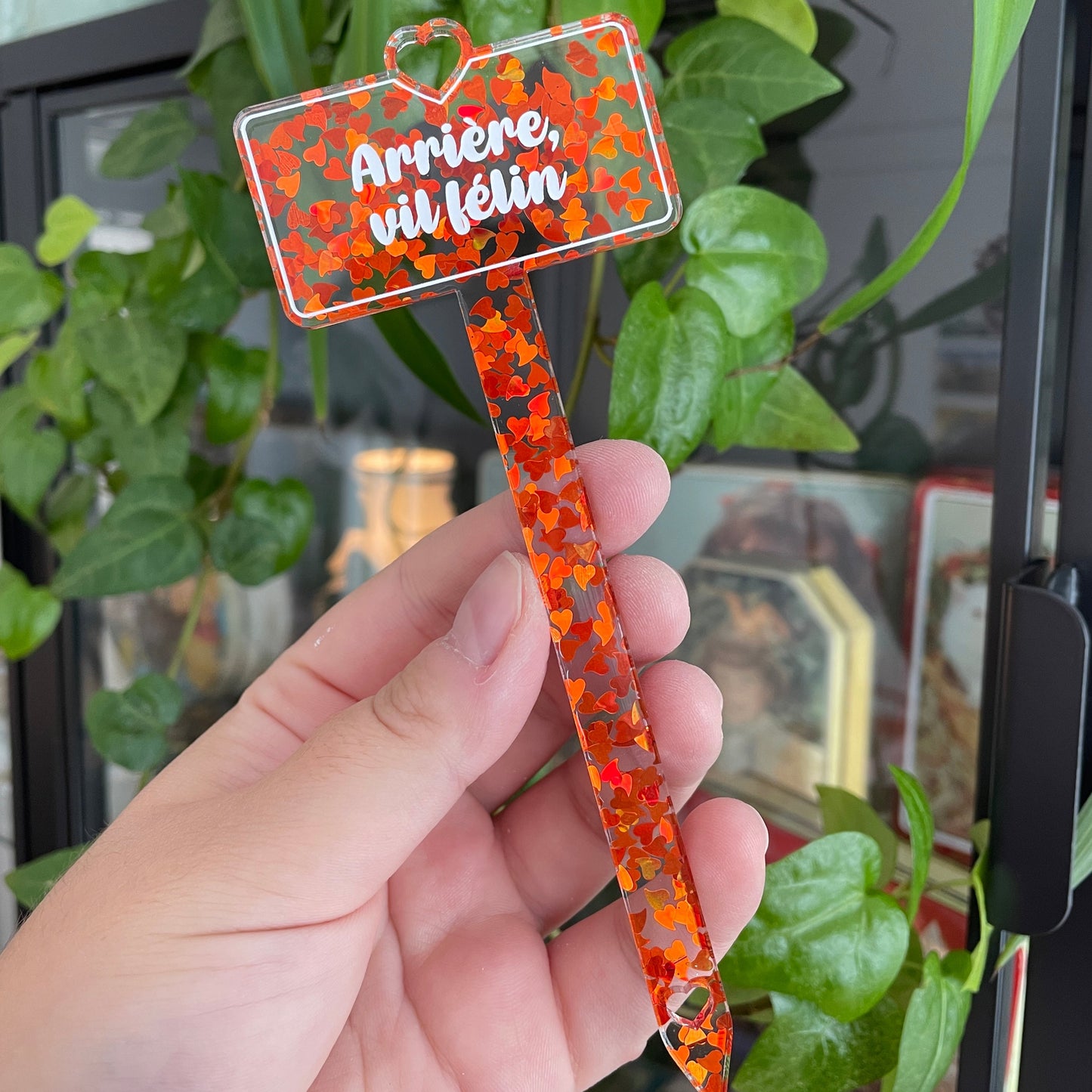 Pic à plante "Arrière, vil félin" en acrylique transparente avec des confettis coeurs oranges