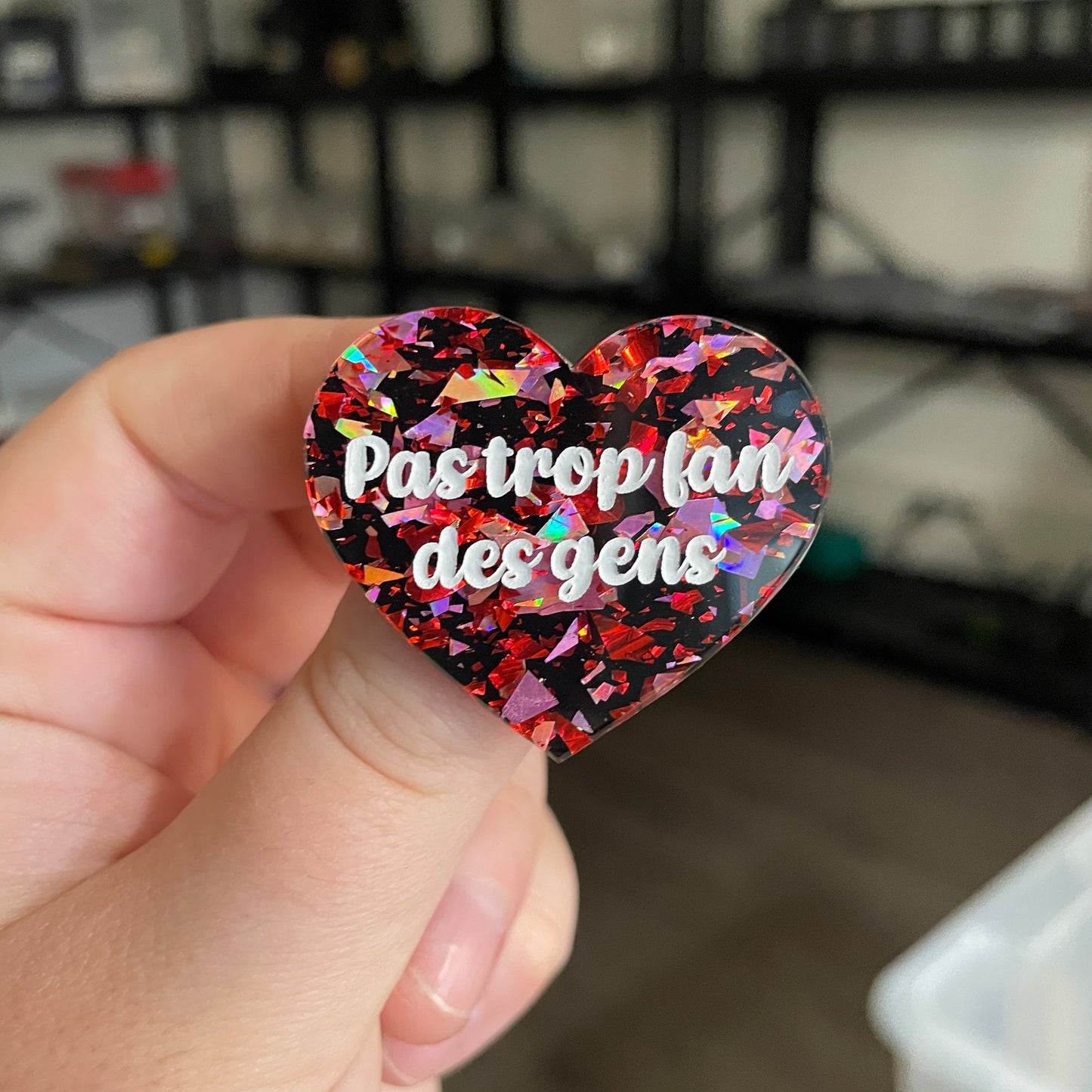Broche "Pas trop fan des gens" en acrylique noire avec des éclats de confettis rouges et roses
