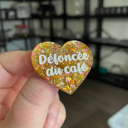 Broche "Défoncée au café" en acrylique transparente avec des confettis jaunes