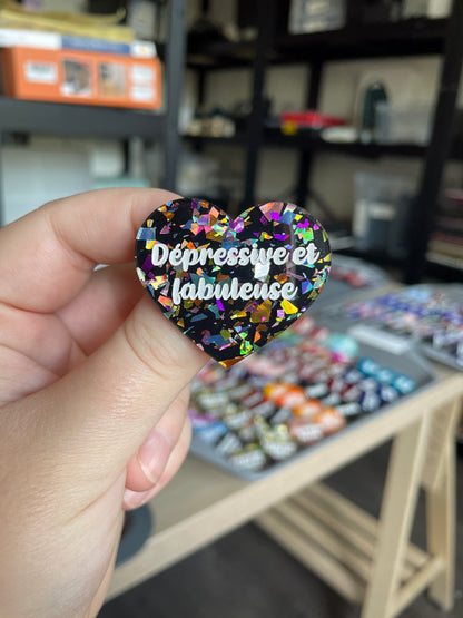 [CONTRÔLE TECHNIQUE] Broche "Dépressive et fabuleuse" en acrylique noire avec des éclats de confettis multicolores