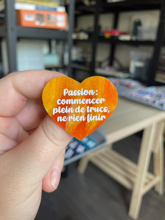 [CONTRÔLE TECHNIQUE] Broche "Passion : commencer plein de trucs, ne rien finir" en acrylique marbrée orange et dorée à paillettes