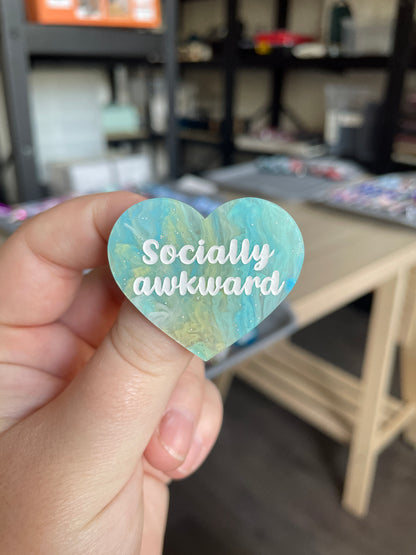 [CONTRÔLE TECHNIQUE] Broche "Socially awkward" en acrylique marbrée semi-transparente bleue, turquoise, blanche et jaune à paillettes