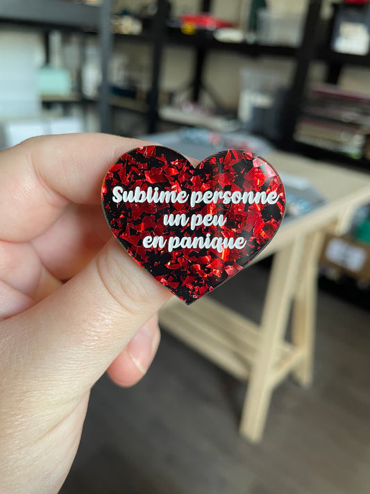 [CONTRÔLE TECHNIQUE] Broche "Sublime personne un peu en panique" en acrylique noire avec des éclats de confettis rouges