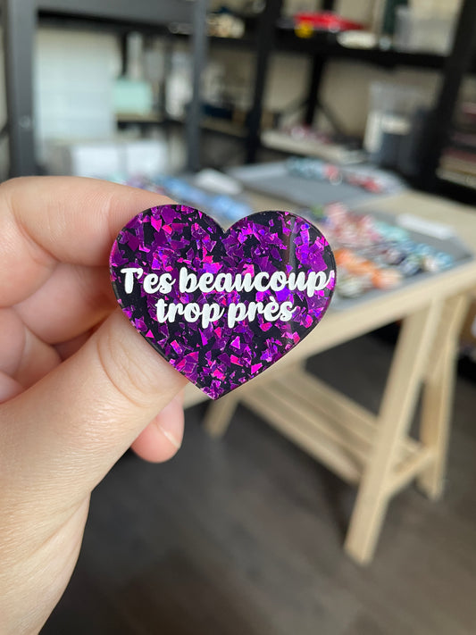[CONTRÔLE TECHNIQUE] Broche "T'es beaucoup trop près" en acrylique noire avec des éclats de confettis violets