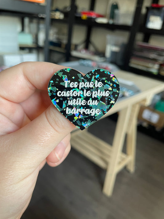 [CONTRÔLE TECHNIQUE] Broche "T'es pas le castor le plus utile au barrage" en acrylique noire avec des éclats de confettis turquoise