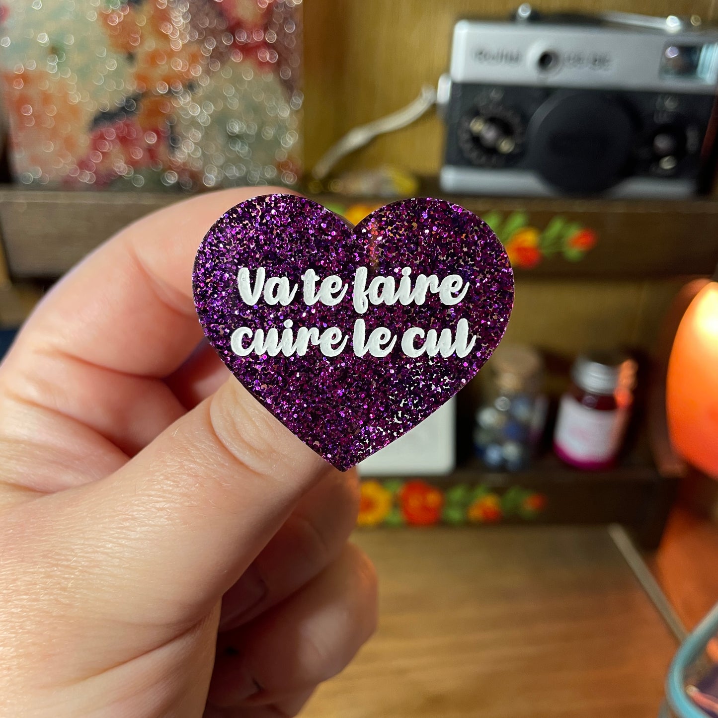 Broche "Va te faire cuire le cul" en acrylique à paillettes violettes