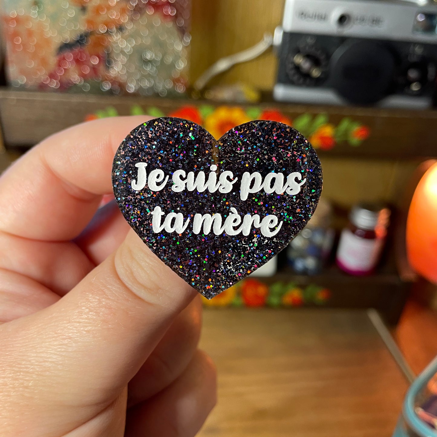 Broche "Je suis pas ta mère" en acrylique à paillettes holographiques noires