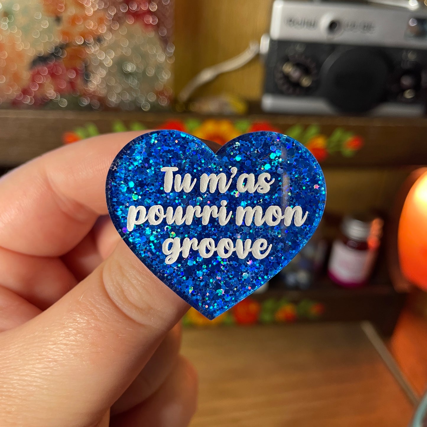 Broche "Tu m'as pourri mon groove" en acrylique semi transparente à paillettes bleues