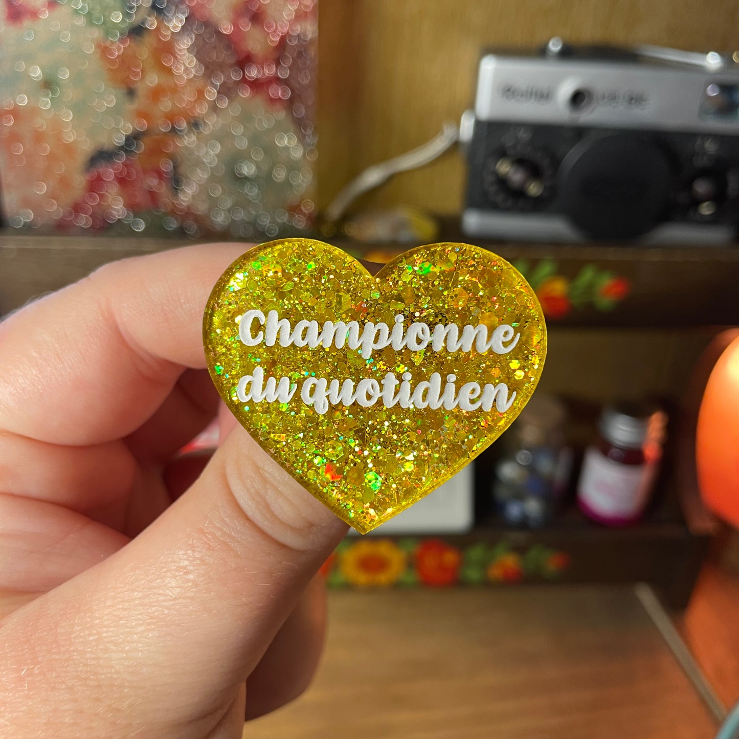 Broche "Championne du quotidien" en acrylique semi transparente à paillettes jaunes