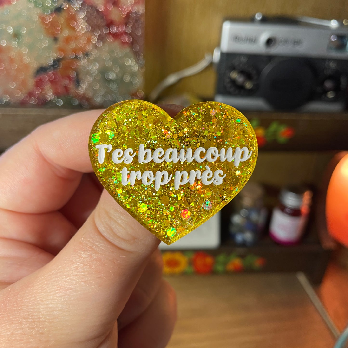 Broche "T'es beaucoup trop près" en acrylique semi transparente à paillettes jaunes