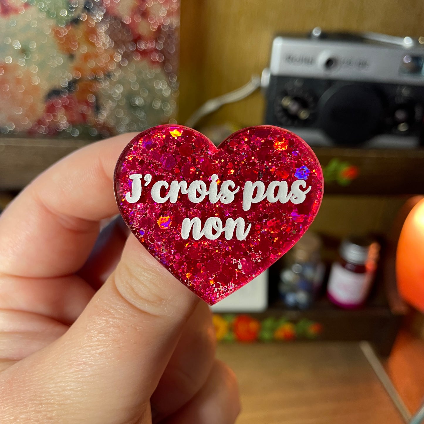 Broche "J'crois pas non" en acrylique semi transparente à paillettes rouges
