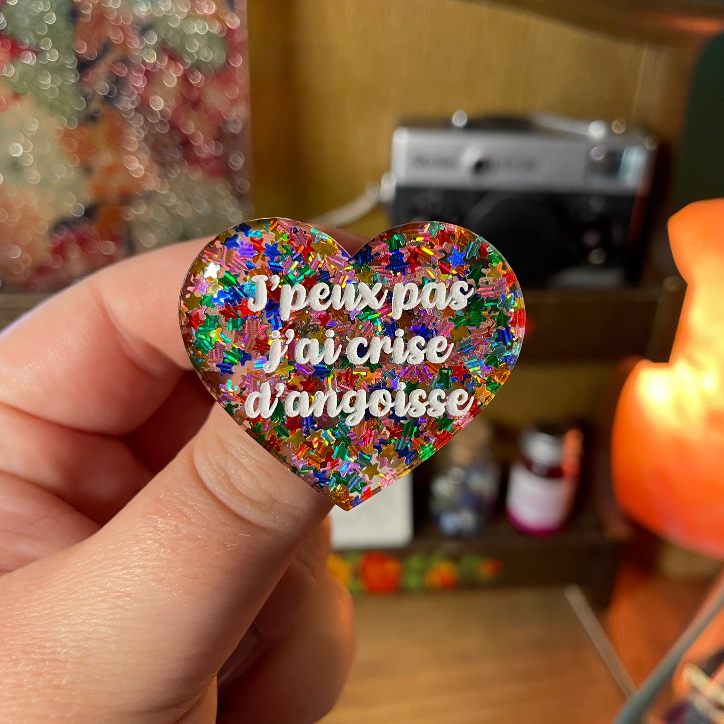 Broche "J'peux pas j'ai crise d'angoisse" en acrylique semi transparente avec des étoiles multicolores
