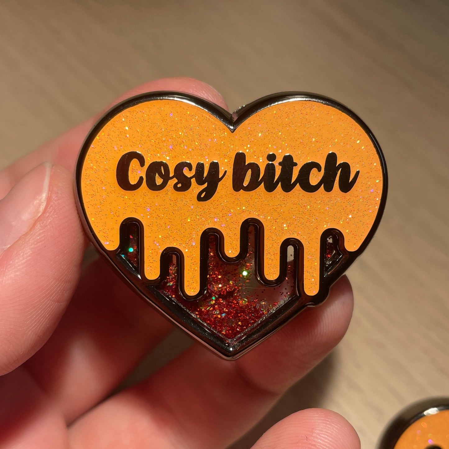 Pin en émail "Cosy bitch" orange à paillettes et paillettes liquides