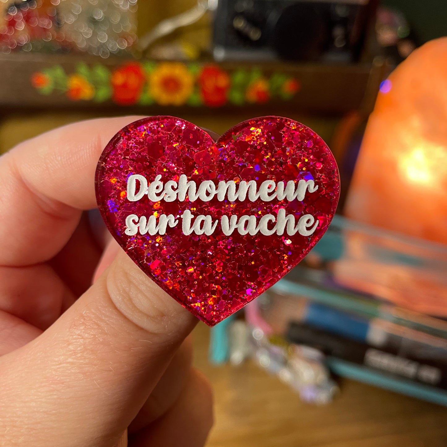 Broche "Déshonneur sur ta vache" en acrylique semi transparente à paillettes rouges