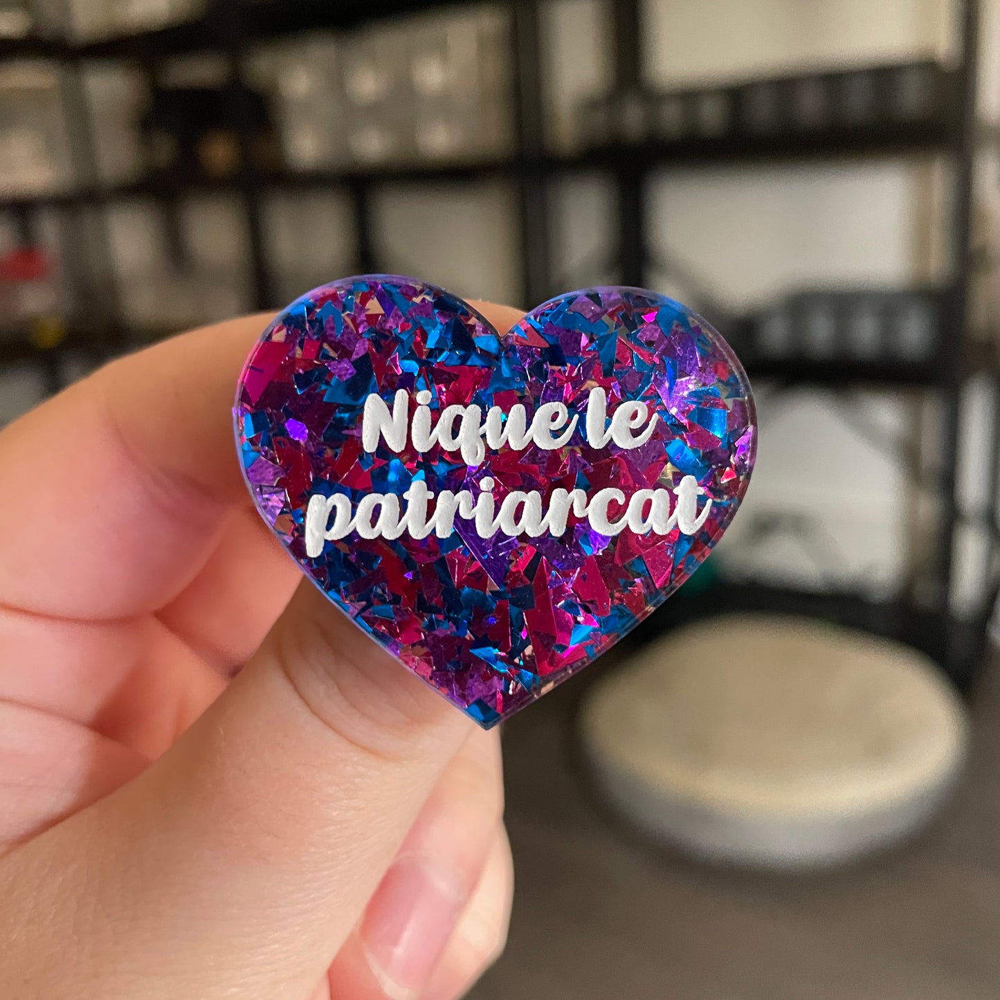 Broche "Nique le patriarcat" en acrylique transparente avec des confettis bleus et roses