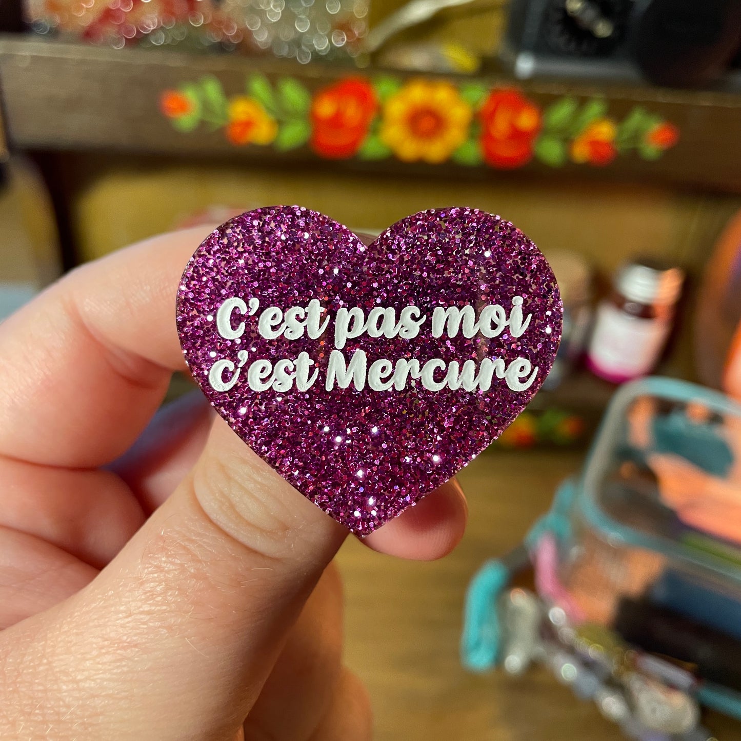 Broche "C'est pas moi c'est Mercure" en acrylique à paillettes violettes