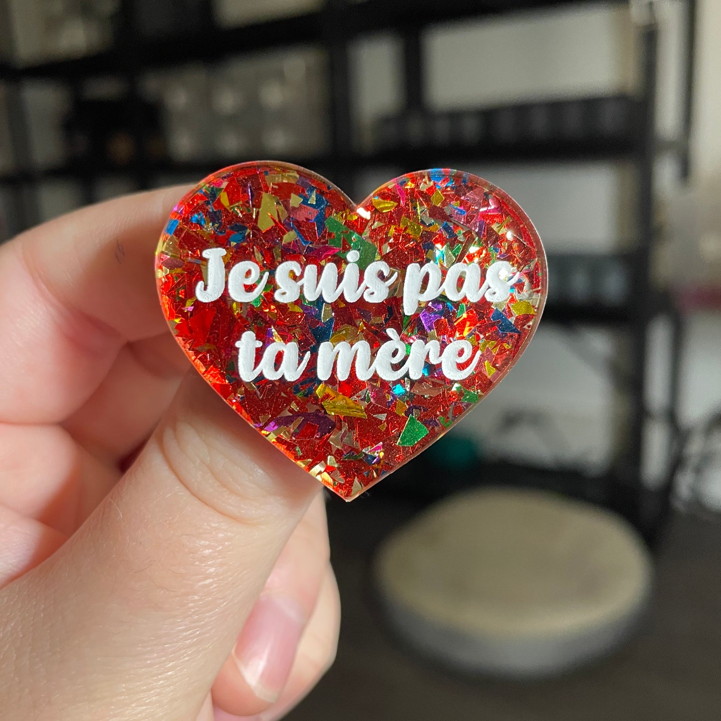 Broche "Je suis pas ta mère" en acrylique transparente avec des confettis rouges et multicolores