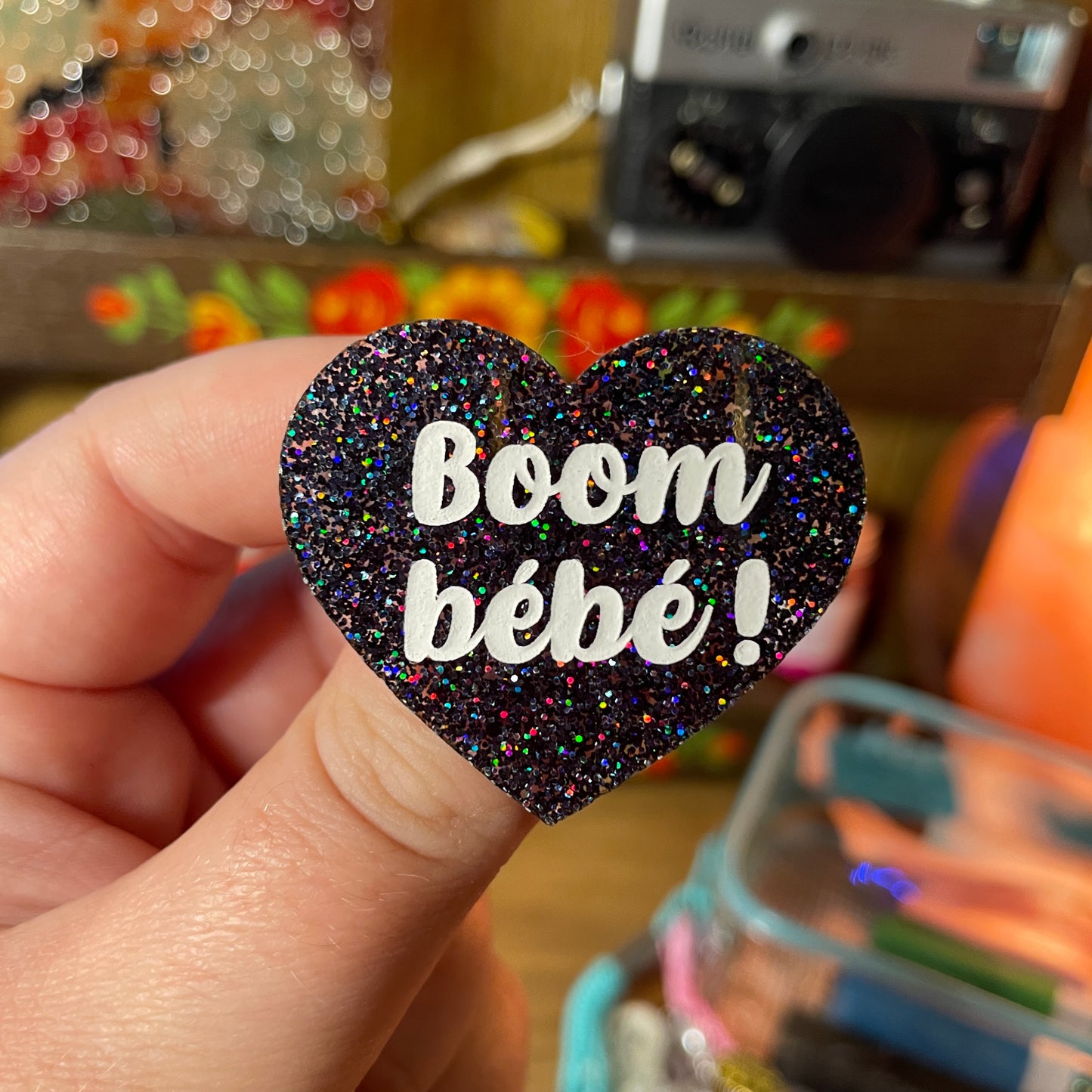 Broche "Boom bébé !" en acrylique à paillettes noires holographiques