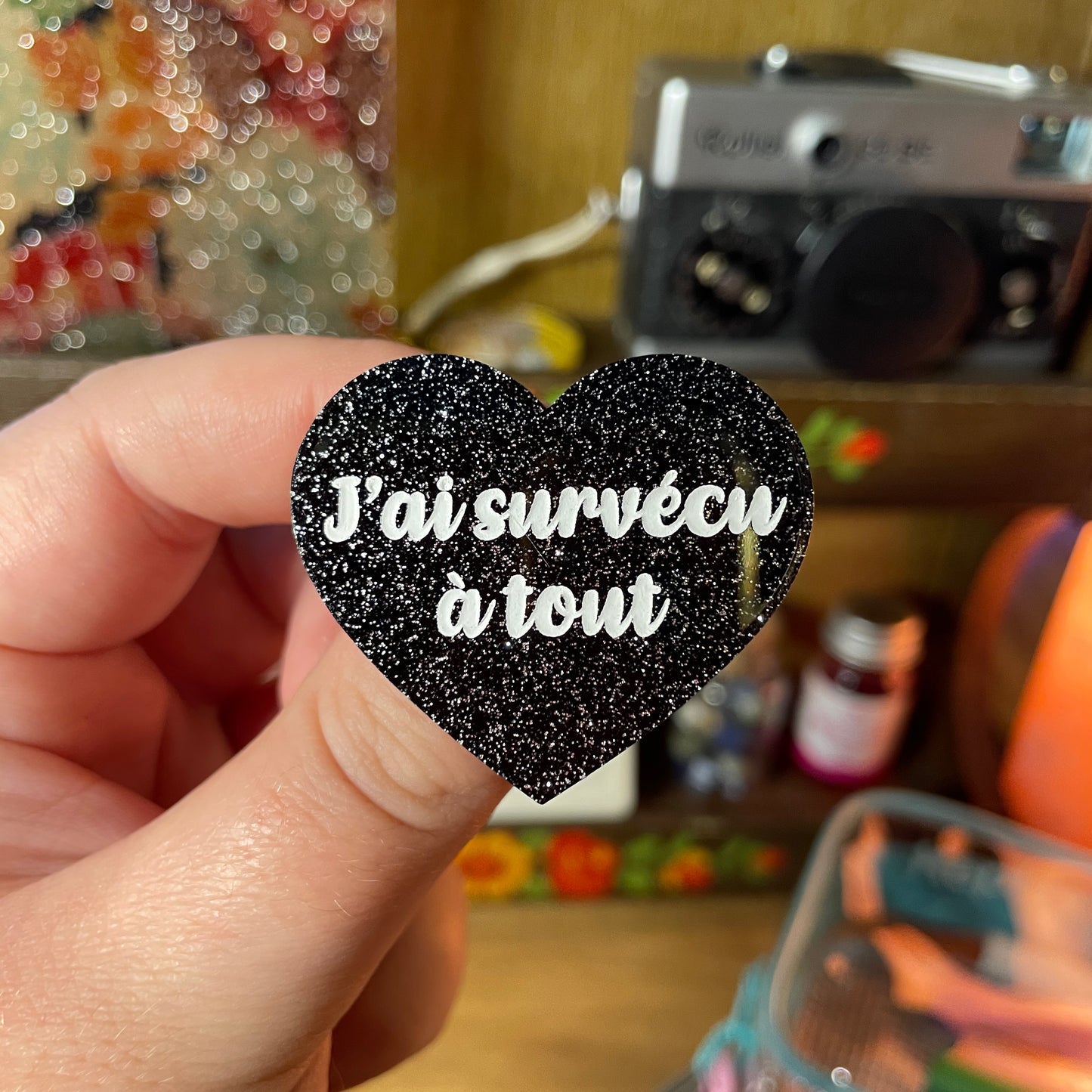 Broche "J'ai survécu à tout" en acrylique noire à paillettes