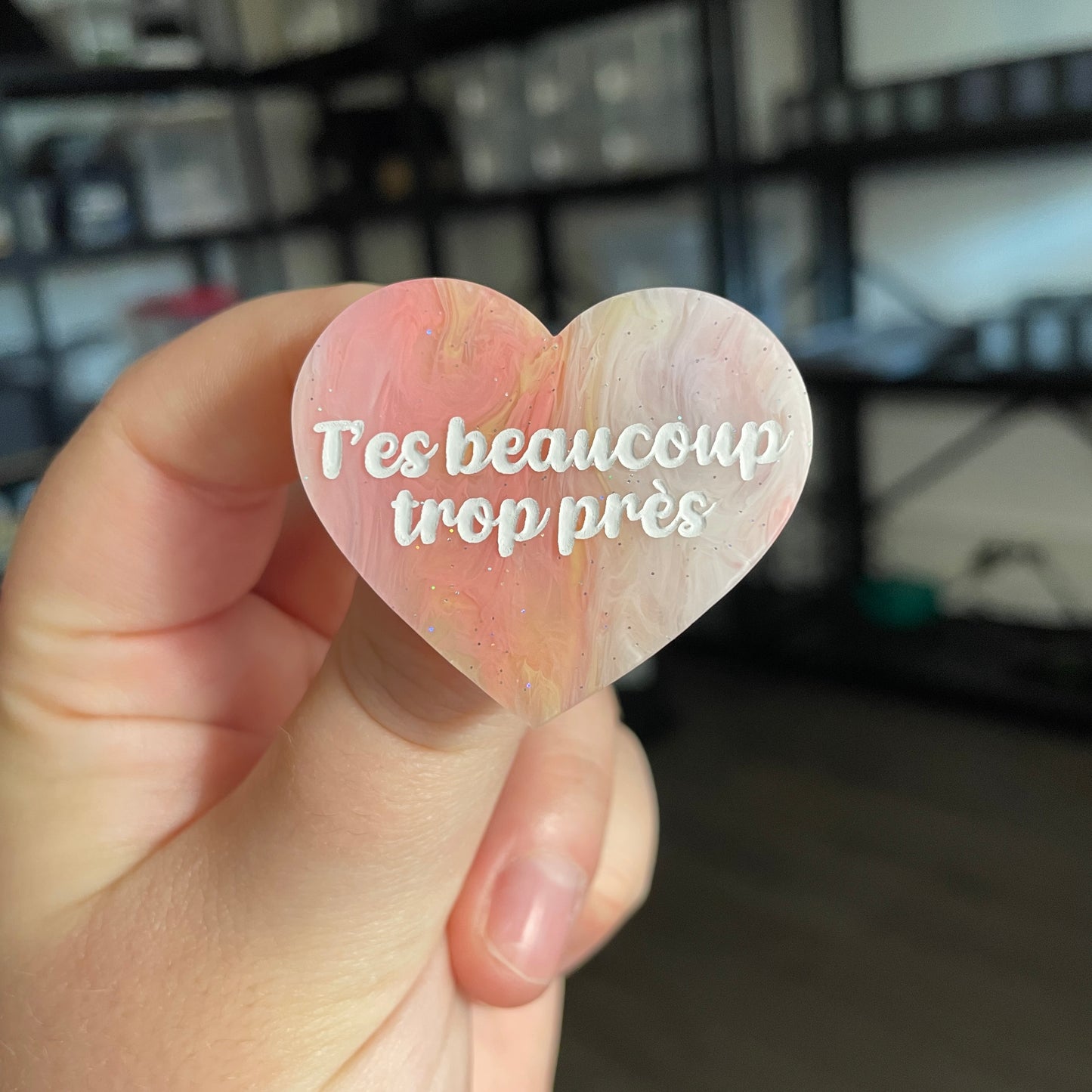 Broche "T'es beaucoup trop près" en acrylique marbrée corail, orange, jaune et blanche à paillettes
