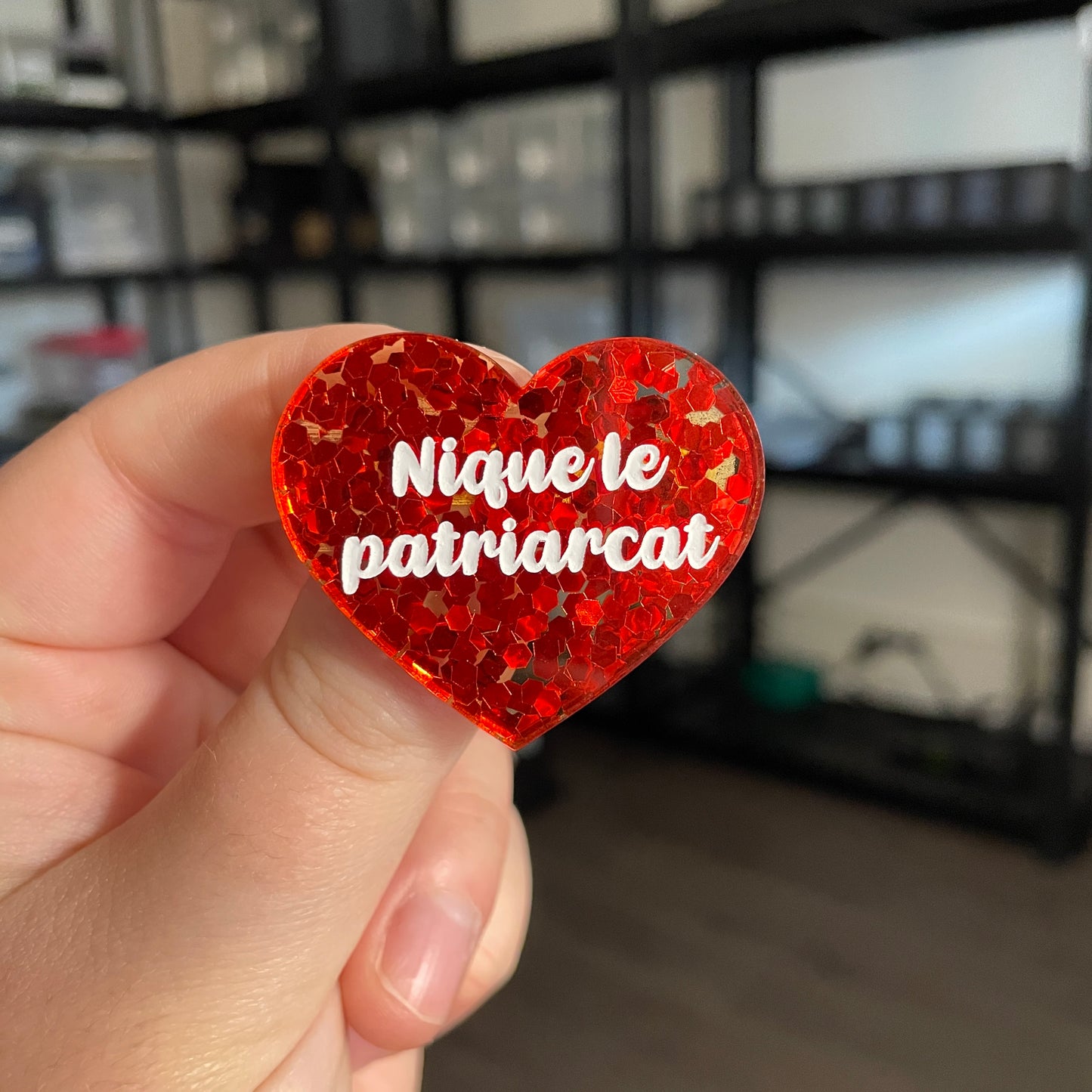 Broche "Nique le patriarcat" en acrylique semi transparente avec des confettis rouges