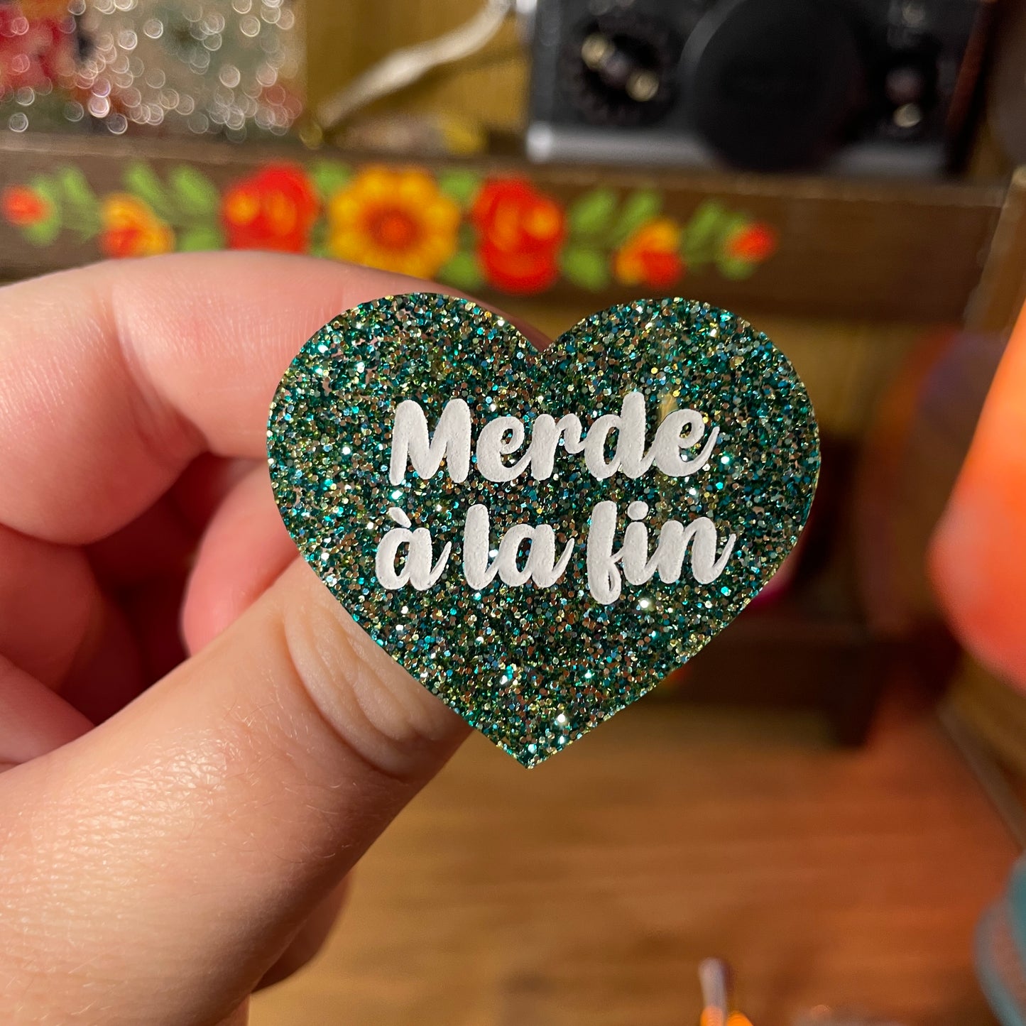 Broche "Merde à la fin" en acrylique à paillettes vertes